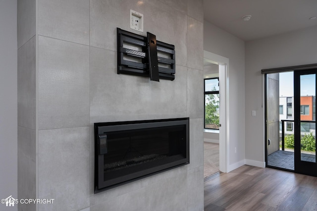 528 Coastal Pl # 1, Anchorage, AK 99501 - detailed view of wood finished floors, baseboards, a fireplace, and a smoke detector