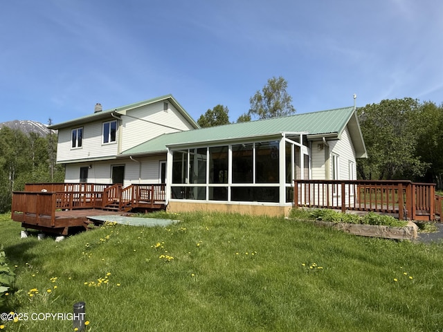 9810 N Runyon Cir, Palmer, AK 99645 - back of property with a sunroom, a wooden deck, a chimney, and a lawn