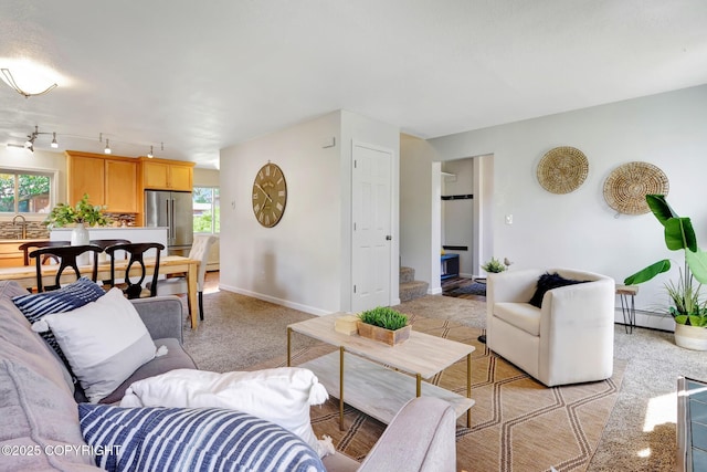 6831 Cheryl St, Anchorage, AK 99518 - living area with healthy amount of natural light, a baseboard heating unit, and baseboards