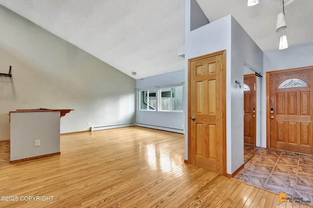 3135 Delta Dr, Anchorage, AK 99502 - entrance foyer with vaulted ceiling, a textured ceiling, hardwood / wood-style flooring, and baseboards