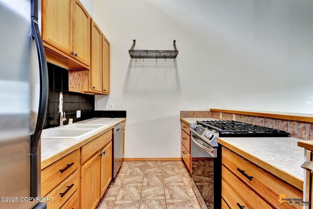 3135 Delta Dr, Anchorage, AK 99502 - kitchen featuring stainless steel appliances, a sink, backsplash, and light countertops