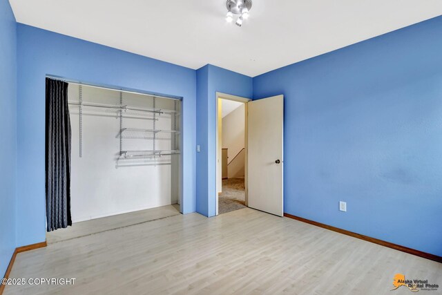 3135 Delta Dr, Anchorage, AK 99502 - unfurnished bedroom with wood finished floors, a closet, and baseboards