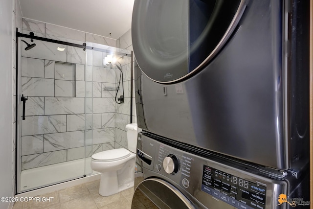 3135 Delta Dr, Anchorage, AK 99502 - bathroom featuring stacked washer / drying machine, a shower stall, toilet, and tile patterned floors