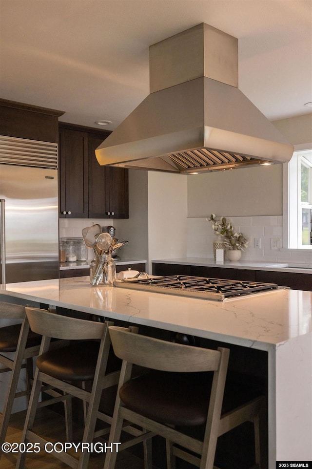 101 Jeff Davis St, Sitka, AK 99835 - kitchen with island range hood, dark brown cabinetry, decorative backsplash, and a breakfast bar