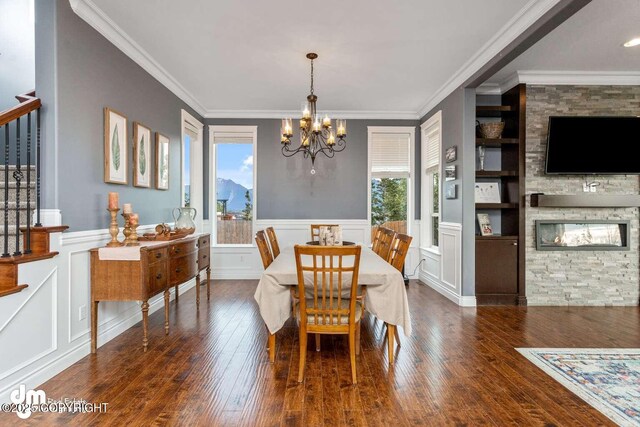 5044 E Loft Cir, Wasilla, AK 99654 - dining room featuring a chandelier, a decorative wall, built in features, stairway, and wood finished floors