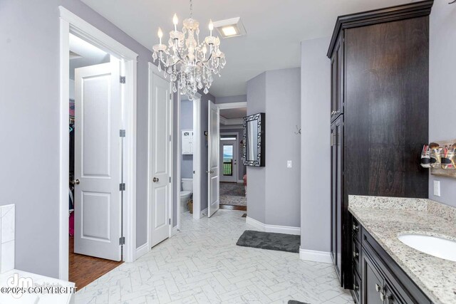 5044 E Loft Cir, Wasilla, AK 99654 - bathroom with a chandelier, toilet, baseboards, and vanity