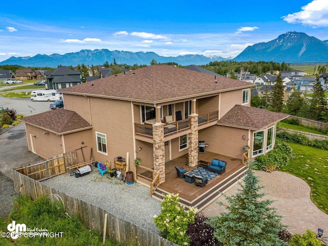5044 E Loft Cir, Wasilla, AK 99654 - rear view of property with a balcony, a fenced backyard, a deck with mountain view, a residential view, and a shingled roof