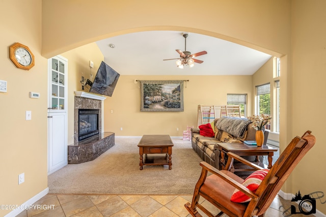 3474 E Wanamingo Dr, Wasilla, AK 99654 - living room featuring carpet floors, ceiling fan, a fireplace, arched walkways, and a high ceiling