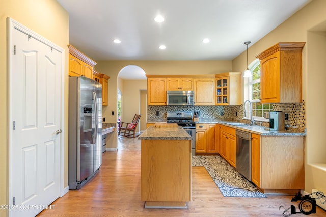3474 E Wanamingo Dr, Wasilla, AK 99654 - kitchen with appliances with stainless steel finishes, a center island, arched walkways, light wood-style floors, and recessed lighting