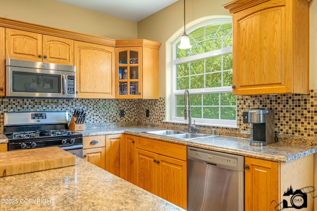 3474 E Wanamingo Dr, Wasilla, AK 99654 - kitchen featuring appliances with stainless steel finishes, glass insert cabinets, pendant lighting, backsplash, and light countertops