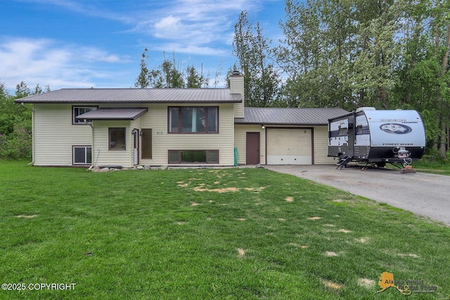 910 S Iris Cir, Palmer, AK 99645 - view of front of home with a garage, a chimney, driveway, metal roof, and a front lawn