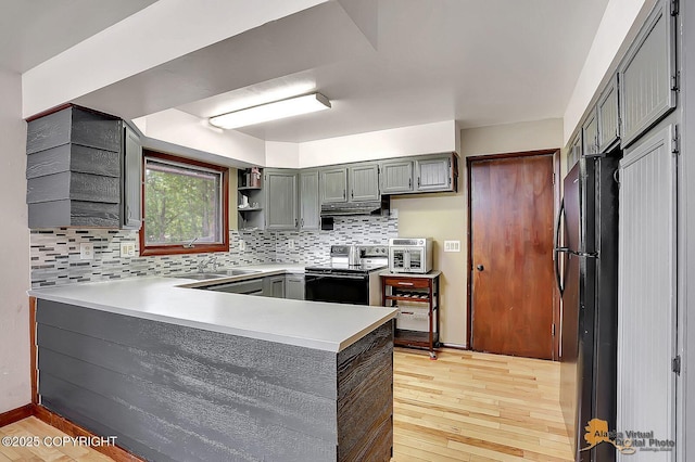 910 S Iris Cir, Palmer, AK 99645 - kitchen featuring stainless steel electric stove, a peninsula, freestanding refrigerator, light wood-style floors, and gray cabinets