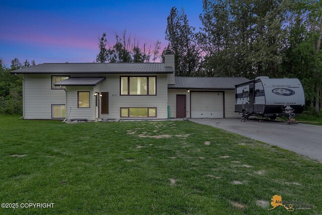 910 S Iris Cir, Palmer, AK 99645 - view of front facade with a chimney, an attached garage, driveway, and a front yard
