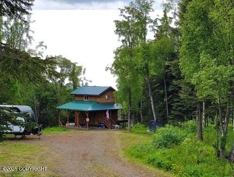 12829 Frontage Rd, Ninilchik, AK 99639 - view of front facade with covered porch, stairway, and driveway