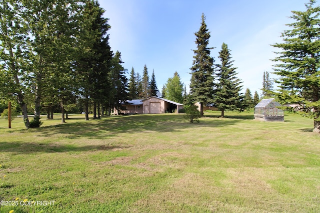 63550 Jessica G Ct, Ninilchik, AK 99639 - view of grassy yard featuring an outbuilding, a greenhouse, and a garage