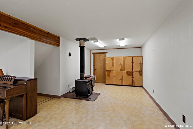 7550 E Fireweed Rd, Palmer, AK 99645 - below grade area featuring a wood stove, a baseboard radiator, and baseboards