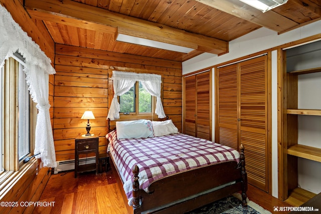 7550 E Fireweed Rd, Palmer, AK 99645 - bedroom with baseboard heating, wood ceiling with exposed beams, multiple closets, wood finished floors, and wooden walls