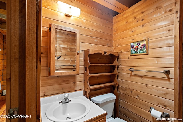 7550 E Fireweed Rd, Palmer, AK 99645 - bathroom featuring wood walls, toilet, and vanity