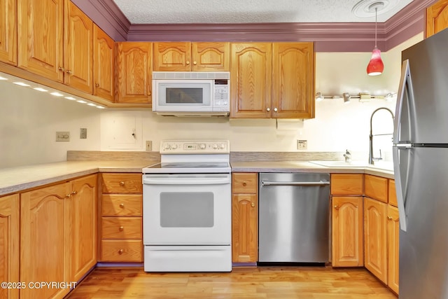 836 O Pl, Anchorage, AK 99501 - kitchen with appliances with stainless steel finishes, a textured ceiling, light wood finished floors, hanging light fixtures, and light countertops