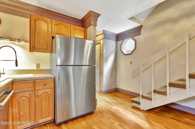836 O Pl, Anchorage, AK 99501 - kitchen featuring stainless steel appliances, a sink, light countertops, light wood finished floors, and a textured ceiling