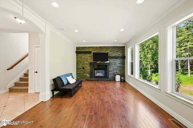 4920 W Fairview Loop, Wasilla, AK 99654 - unfurnished living room featuring healthy amount of natural light, a stone fireplace, ornamental molding, recessed lighting, and stairs