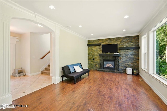 4920 W Fairview Loop, Wasilla, AK 99654 - unfurnished living room with ornate columns, a fireplace, stairs, recessed lighting, and wood finished floors
