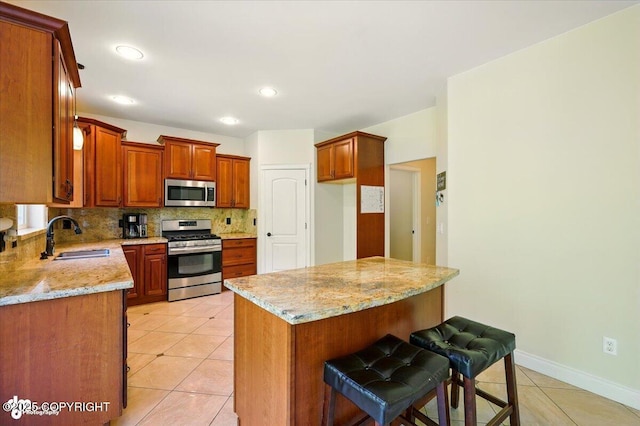 4920 W Fairview Loop, Wasilla, AK 99654 - kitchen with stainless steel appliances, light tile patterned floors, backsplash, light stone counters, and a center island