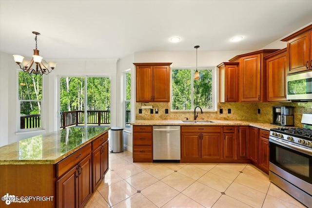 4920 W Fairview Loop, Wasilla, AK 99654 - kitchen with appliances with stainless steel finishes, tasteful backsplash, light stone counters, and a chandelier