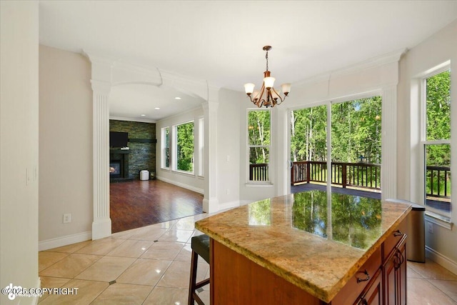4920 W Fairview Loop, Wasilla, AK 99654 - kitchen featuring plenty of natural light, a chandelier, light tile patterned floors, crown molding, and light stone countertops