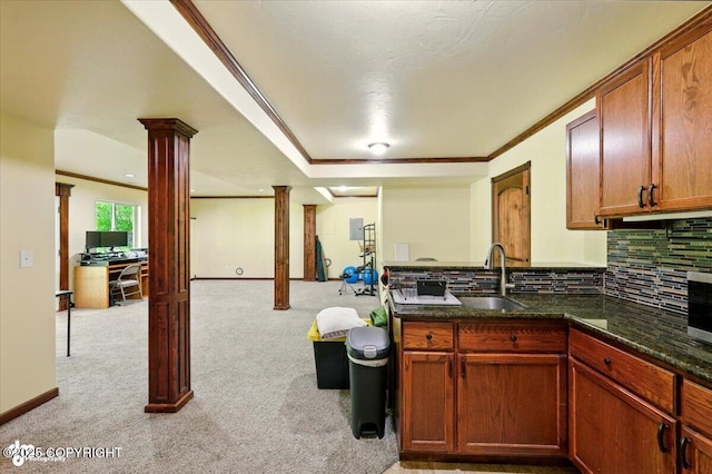 4920 W Fairview Loop, Wasilla, AK 99654 - kitchen with crown molding, decorative backsplash, light colored carpet, decorative columns, and dark stone counters