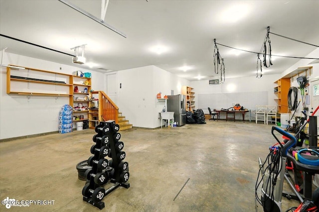 4920 W Fairview Loop, Wasilla, AK 99654 - garage with a garage door opener and stainless steel refrigerator with ice dispenser