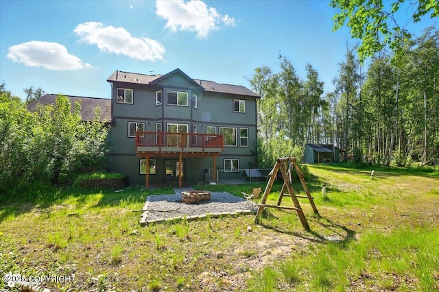 4920 W Fairview Loop, Wasilla, AK 99654 - rear view of house with a fire pit, a deck, and a lawn
