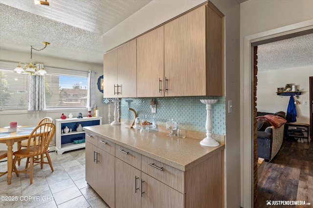 4417 San Roberto Ave, Anchorage, AK 99508 - kitchen featuring a textured ceiling, decorative backsplash, light brown cabinets, and a chandelier