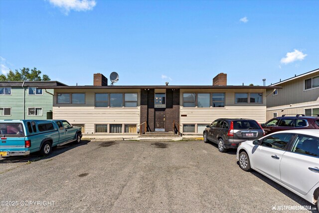 4417 San Roberto Ave, Anchorage, AK 99508 - view of front of property with a chimney, brick siding, and uncovered parking