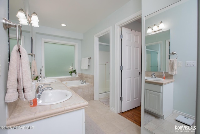 2690 E Tamarak Ave, Wasilla, AK 99654 - bathroom with double vanity, a stall shower, tile patterned floors, a garden tub, and recessed lighting