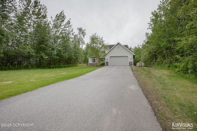 2690 E Tamarak Ave, Wasilla, AK 99654 - view of front facade featuring asphalt driveway, a front lawn, an attached garage, and a chimney