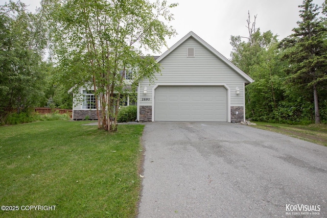 2690 E Tamarak Ave, Wasilla, AK 99654 - view of front of house with stone siding, a garage, and asphalt driveway