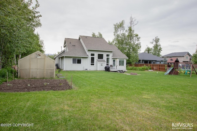 2690 E Tamarak Ave, Wasilla, AK 99654 - rear view of house with a playground, roof with shingles, a deck, and an outbuilding