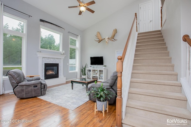 2690 E Tamarak Ave, Wasilla, AK 99654 - living area with wood finished floors, a glass covered fireplace, stairway, a ceiling fan, and lofted ceiling