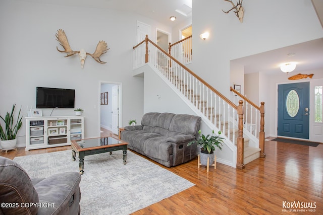 2690 E Tamarak Ave, Wasilla, AK 99654 - living room with stairs, a high ceiling, wood finished floors, and baseboards