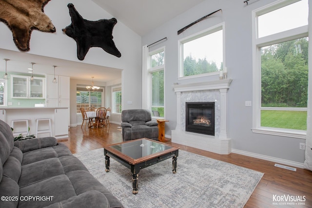 2690 E Tamarak Ave, Wasilla, AK 99654 - living area featuring high vaulted ceiling, healthy amount of natural light, wood finished floors, and a premium fireplace