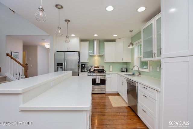 2690 E Tamarak Ave, Wasilla, AK 99654 - kitchen featuring appliances with stainless steel finishes, a sink, wall chimney exhaust hood, tasteful backsplash, and glass insert cabinets