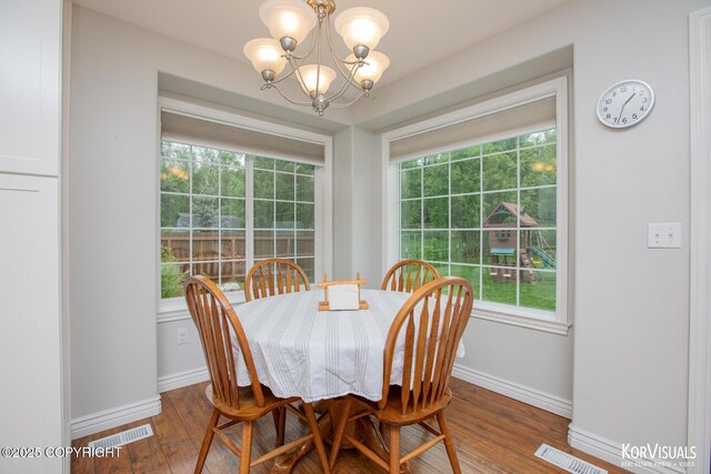 2690 E Tamarak Ave, Wasilla, AK 99654 - dining space featuring a chandelier, wood-type flooring, plenty of natural light, and baseboards