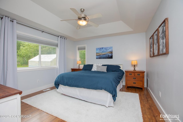 2690 E Tamarak Ave, Wasilla, AK 99654 - bedroom featuring a raised ceiling, wood finished floors, baseboards, and ceiling fan