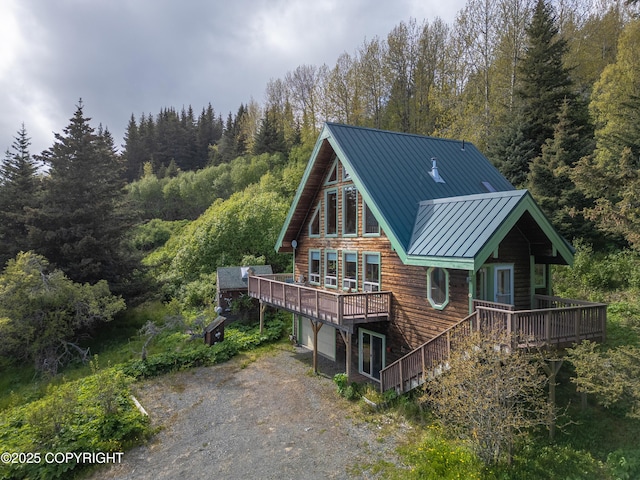 2032 Horizon Ct, Homer, AK 99603 - rear view of house with a standing seam roof, a view of trees, a garage, and a deck
