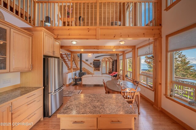 2032 Horizon Ct, Homer, AK 99603 - kitchen with freestanding refrigerator, light brown cabinetry, light wood-style floors, a kitchen island, and baseboards