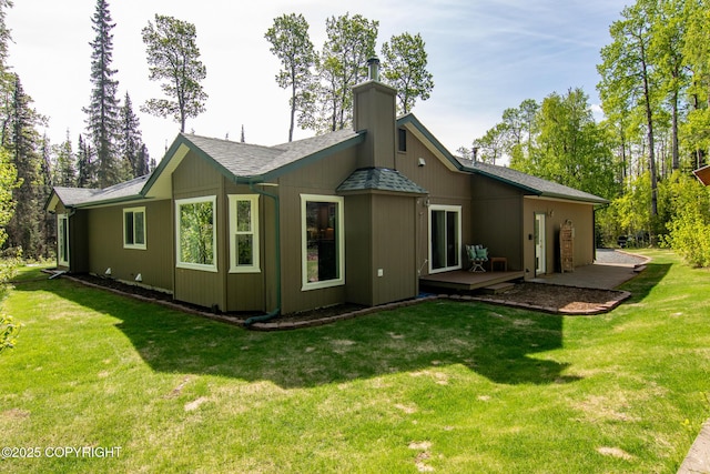 38686 Hart Ct, Soldotna, AK 99669 - rear view of house with a chimney, a lawn, a deck, and roof with shingles
