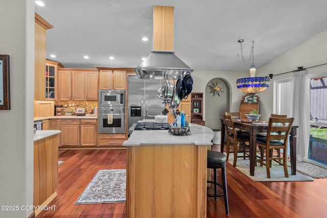 38686 Hart Ct, Soldotna, AK 99669 - kitchen featuring appliances with stainless steel finishes, dark wood finished floors, light countertops, a center island, and decorative backsplash