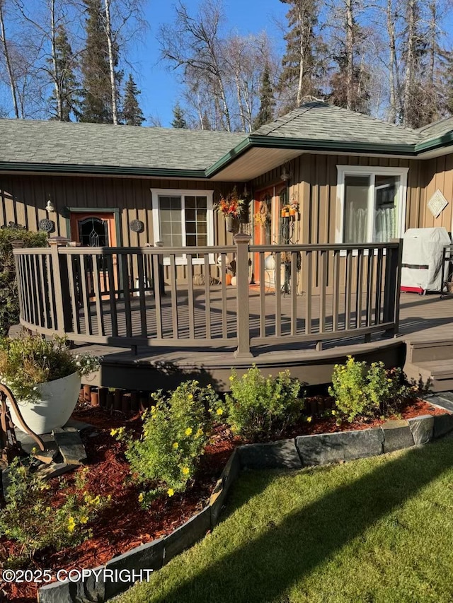38686 Hart Ct, Soldotna, AK 99669 - rear view of house with board and batten siding, a wooden deck, and roof with shingles