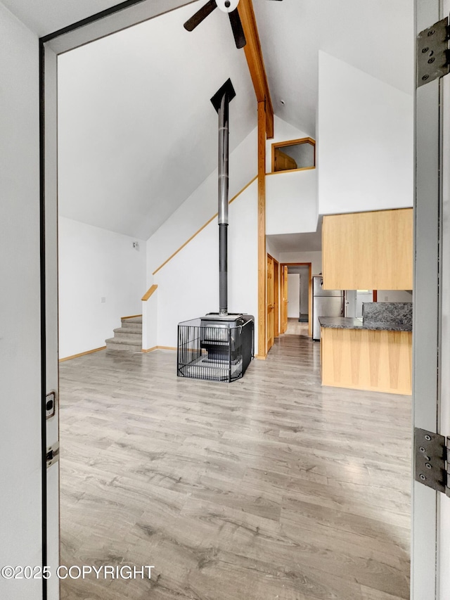 26839 S Talkeetna Spur Rd, Talkeetna, AK 99676 - unfurnished living room with a ceiling fan, beam ceiling, wood finished floors, stairs, and high vaulted ceiling